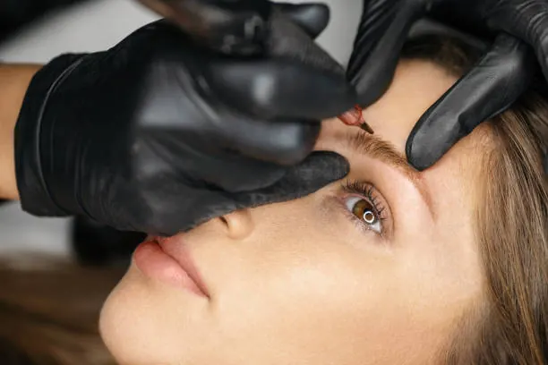 Brow pigment being applied with a fine microblading tool